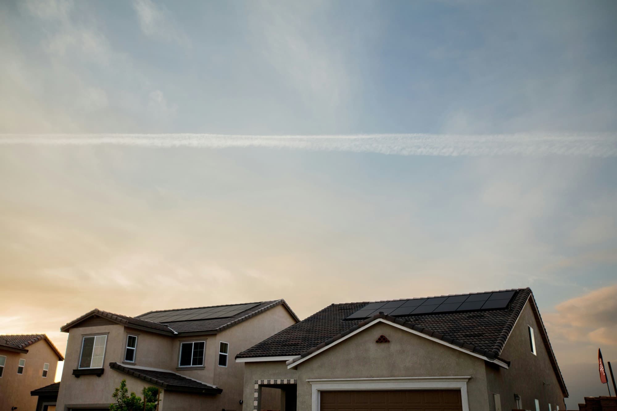 Suburban homes with rooftop solar at golden hour